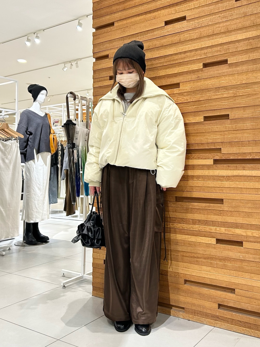 ブラウン系のカーゴパンツ、ベージュ系のダウンジャケット/コート、グレー系のTシャツ/カットソーを着用したレディースの冬コーディネートの2枚目の写真