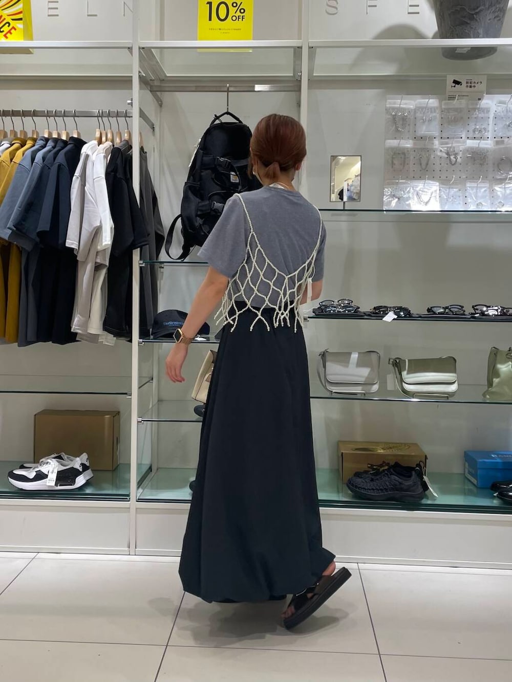 ホワイト系のハンドバッグ、ブラウン系のサンダル、ブルー系のTシャツ/カットソーを着用したレディースの夏コーディネートの3枚目の写真