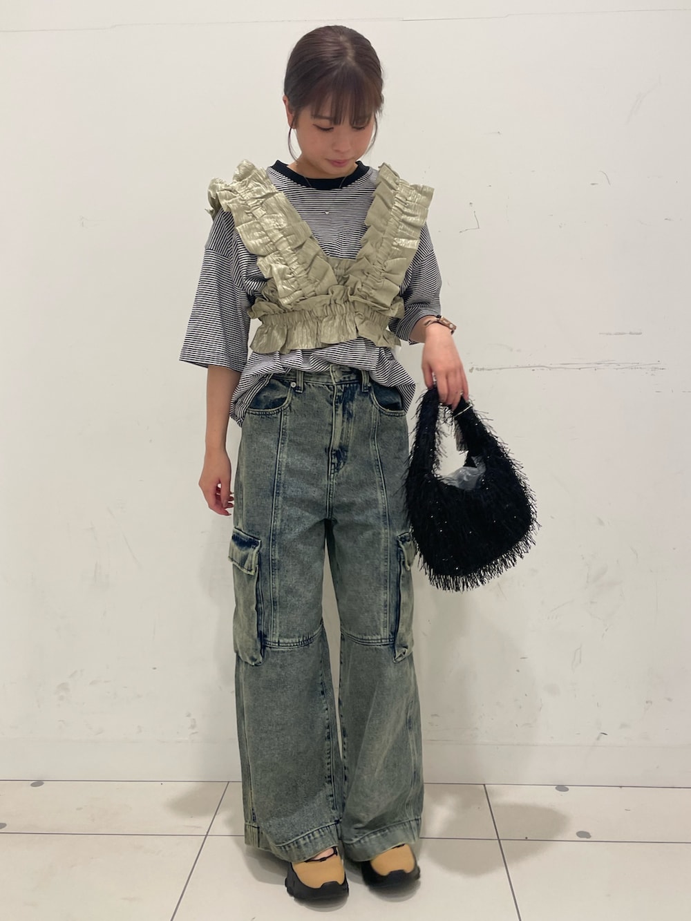 グレー系のデニムパンツ、ベージュ系のベスト、その他のTシャツ/カットソーを着用したレディースの夏コーディネートの2枚目の写真