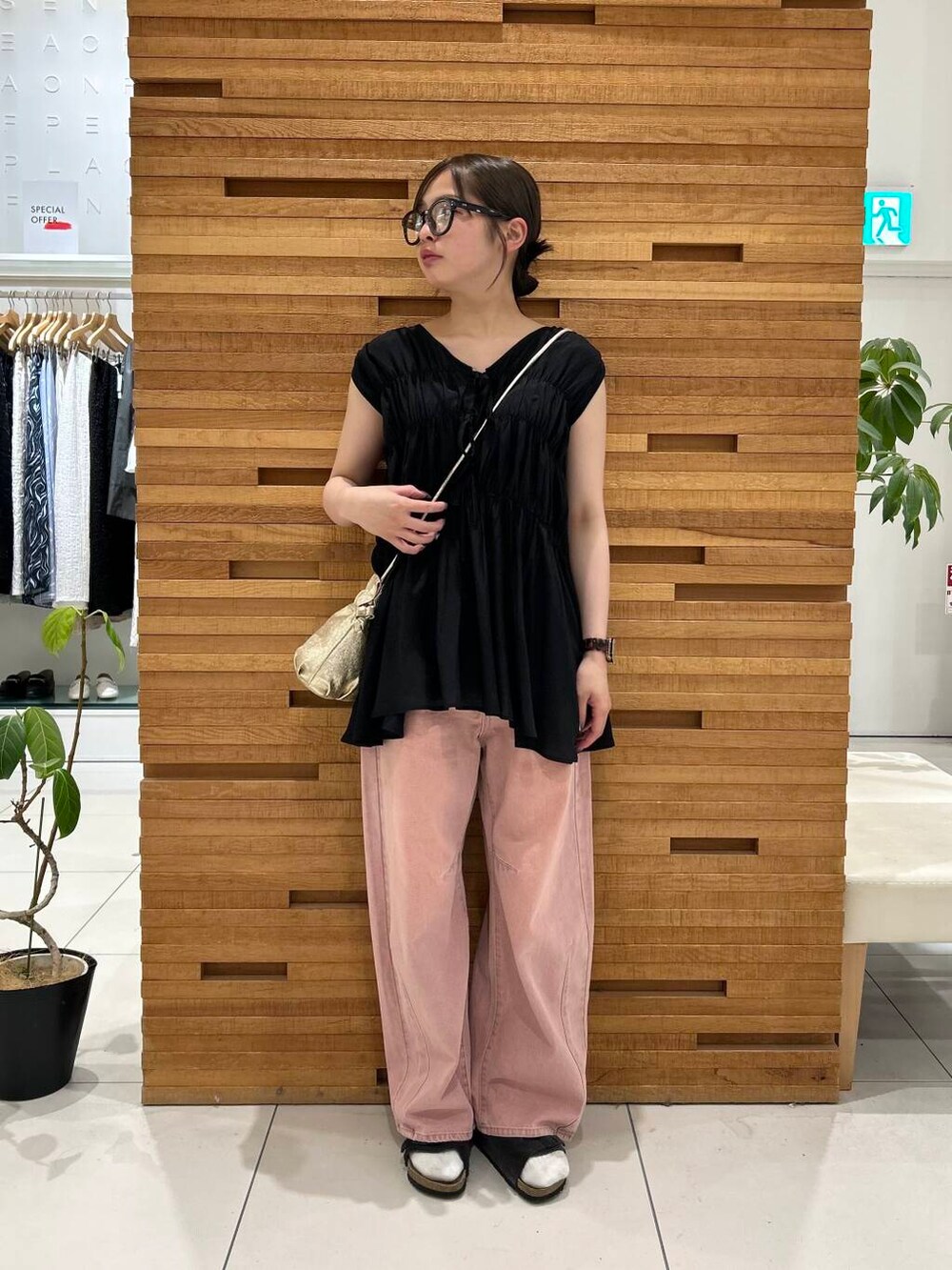 ピンク系のデニムパンツ、ブラック系のシャツ/ブラウスを着用したレディースの夏コーディネートの2枚目の写真