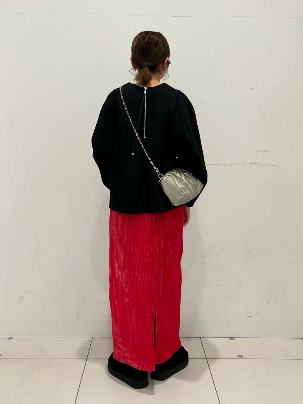 ブラック系のTシャツ/カットソー、レッド系のスカート、シルバー系のショルダーバッグを着用したレディースの冬コーディネートの3枚目の写真