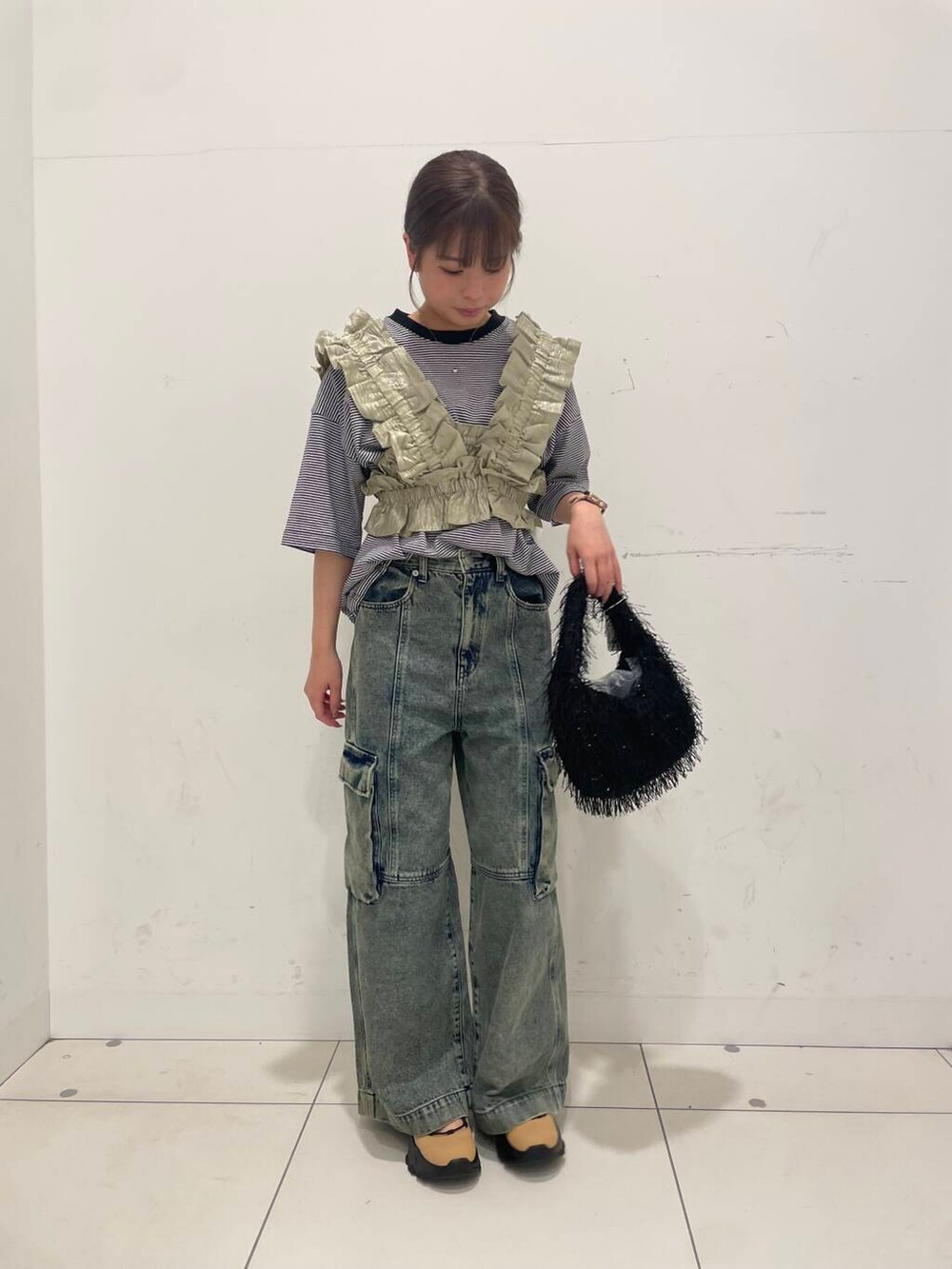 ブラック系のハンドバッグ、その他のTシャツ/カットソー、ベージュ系のベストを着用したレディースの夏コーディネートの2枚目の写真