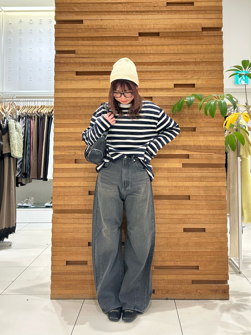 グレー系のデニムパンツ、ブラック系のショルダーバッグ、ブルー系のTシャツ/カットソーを着用したレディースの冬コーディネートの2枚目の写真