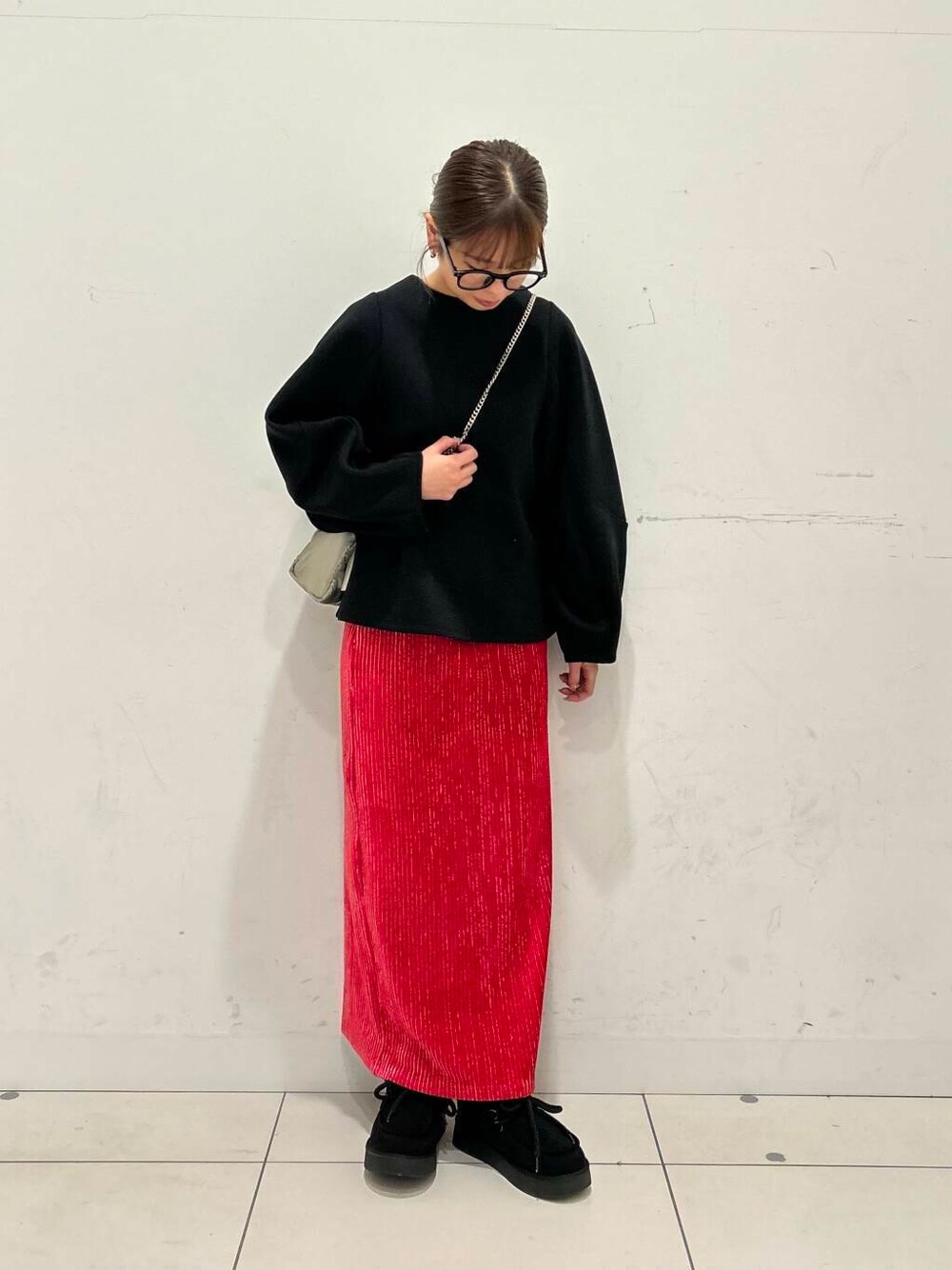 ブラック系のTシャツ/カットソー、レッド系のスカート、シルバー系のショルダーバッグを着用したレディースの冬コーディネートの2枚目の写真