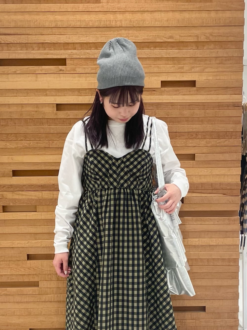 グリーン系のワンピース、ホワイト系のTシャツ/カットソー、シルバー系のトートバッグを着用したレディースの春コーディネートの4枚目の写真