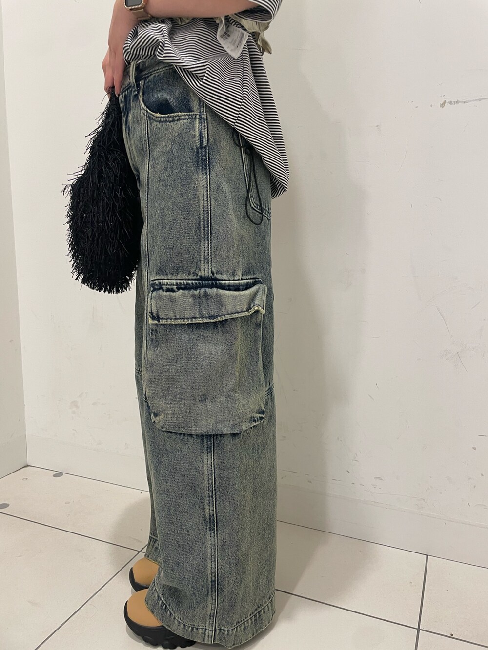 グレー系のデニムパンツ、ベージュ系のベスト、その他のTシャツ/カットソーを着用したレディースの夏コーディネートの4枚目の写真