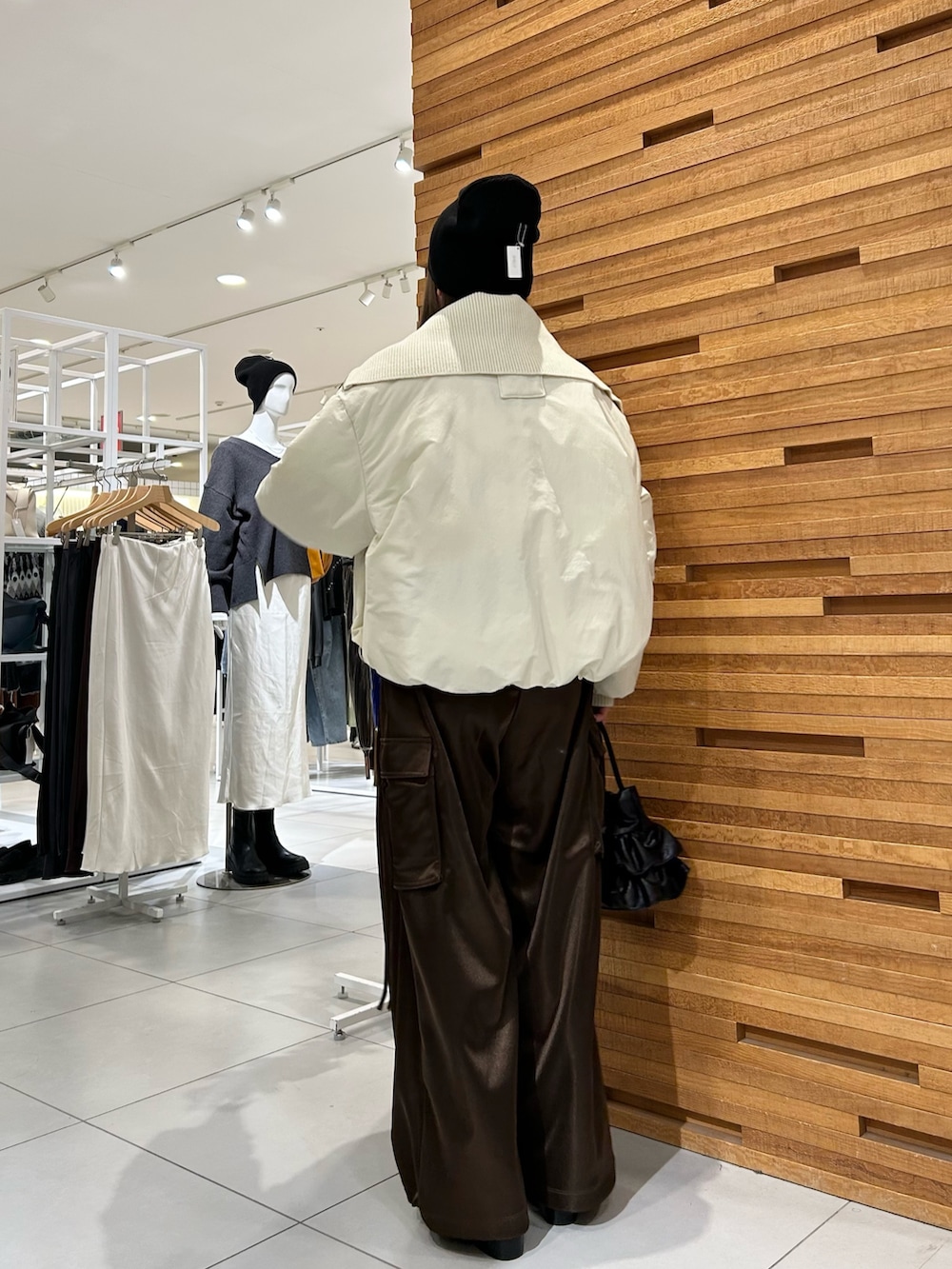 ブラウン系のカーゴパンツ、ベージュ系のダウンジャケット/コート、グレー系のTシャツ/カットソーを着用したレディースの冬コーディネートの3枚目の写真