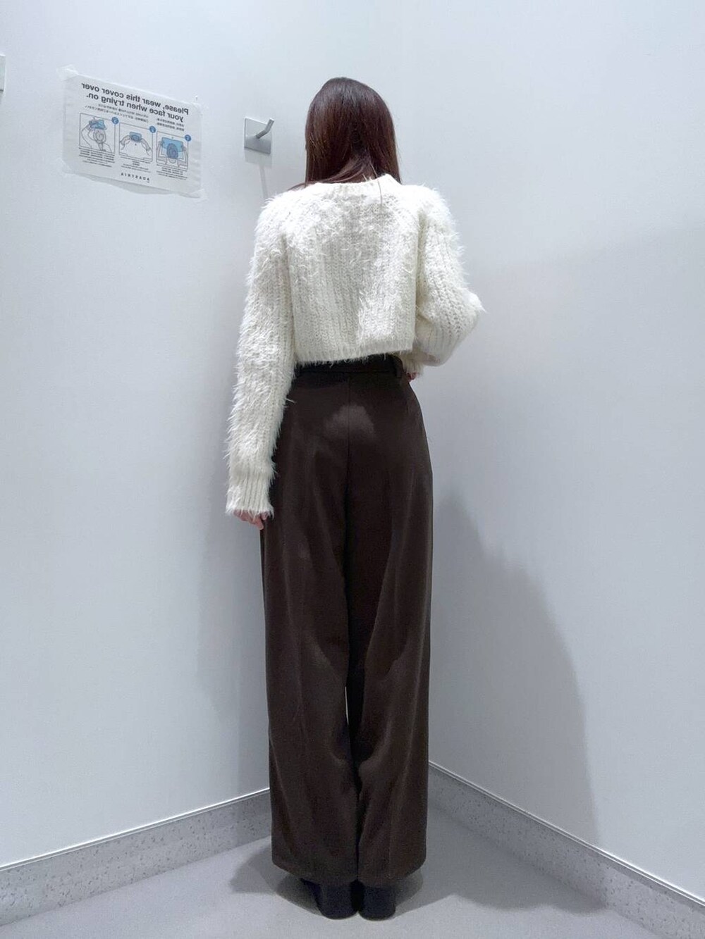 ブラウン系のブーツ、ベージュ系のニット/セーター、ブラウン系のスラックスを着用したレディースの冬コーディネートの2枚目の写真