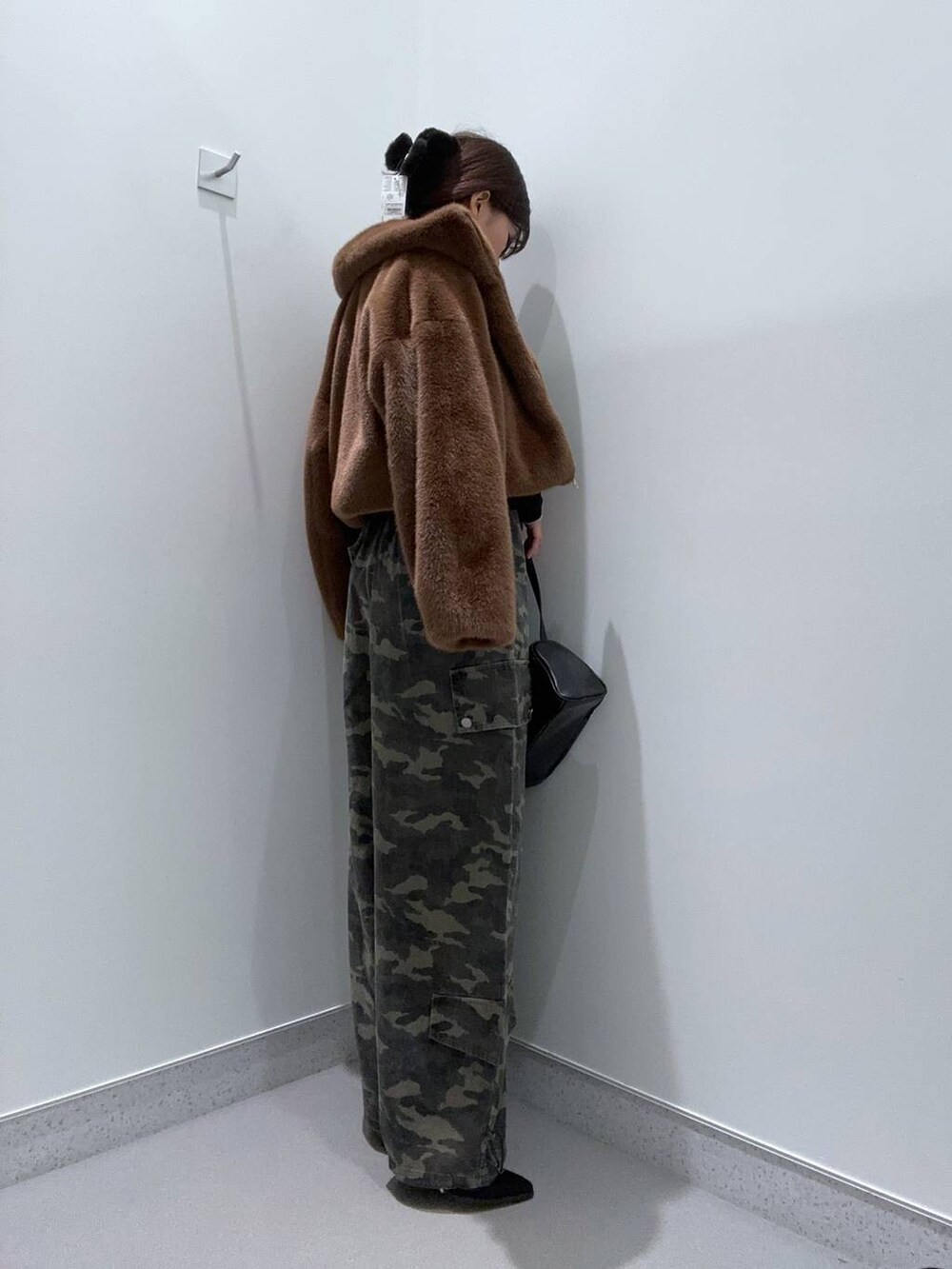 ブラウン系のブルゾン、ブラック系のニット/セーター、ブラック系のショルダーバッグを着用したレディースの秋コーディネートの2枚目の写真