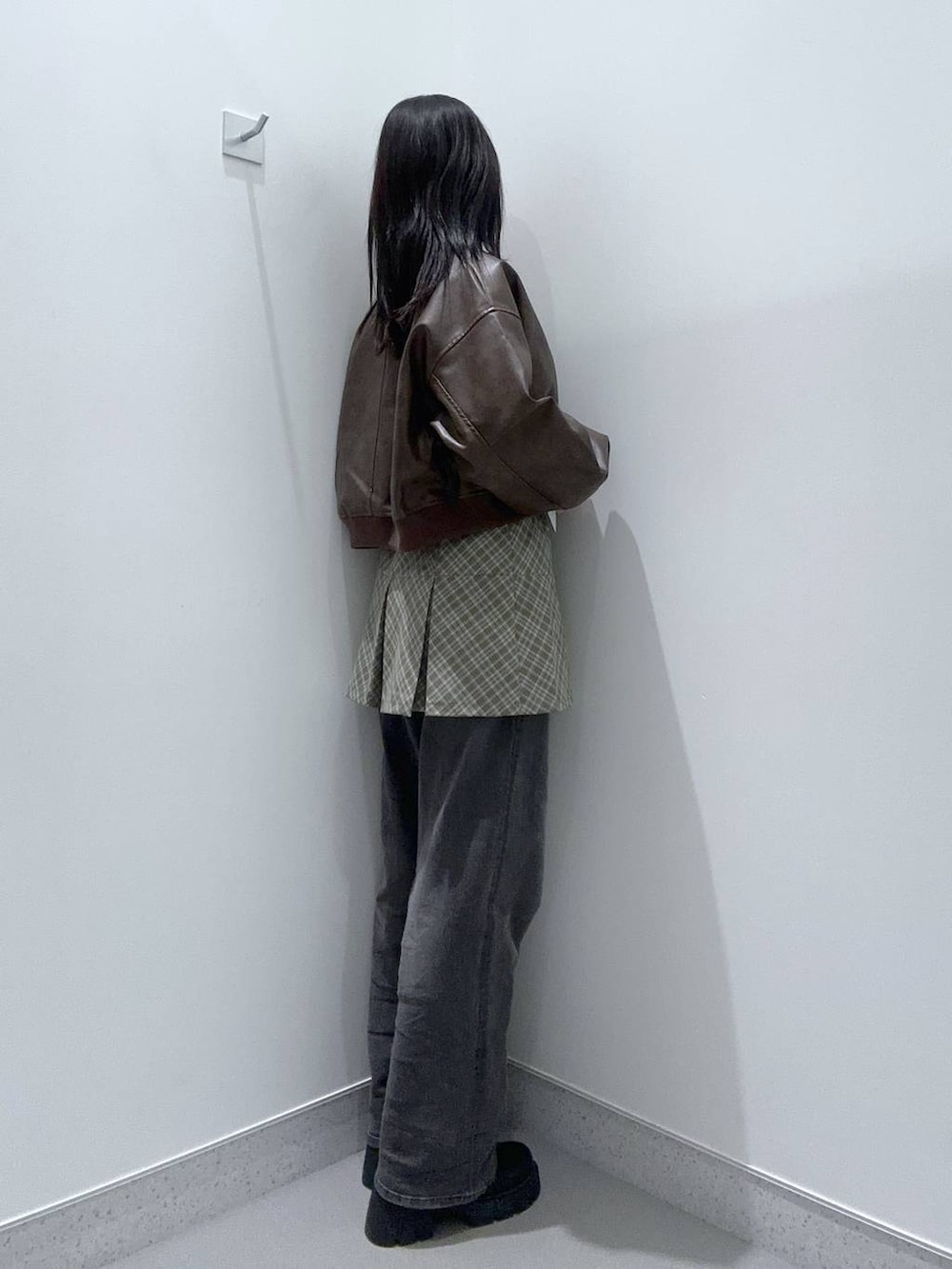 ブラック系のデニムパンツ、ブラック系のブーツ、ブラウン系のMA-1を着用したレディースの冬コーディネートの2枚目の写真