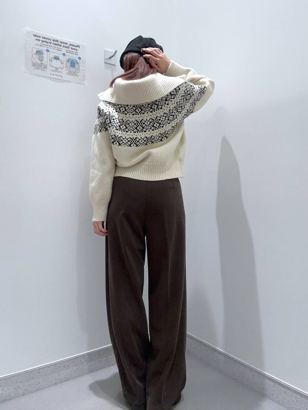 ブラック系のローファー、ベージュ系のニット/セーター、ブラウン系のスラックスを着用したレディースの冬コーディネートの3枚目の写真