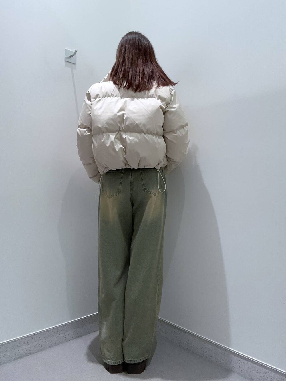 ブルー系のデニムパンツ、ブラウン系のブーツ、ベージュ系のブルゾンを着用したレディースの秋コーディネートの3枚目の写真