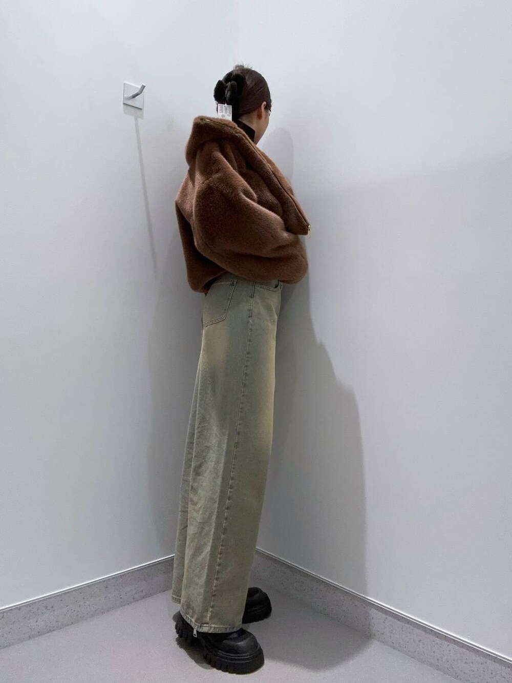 ブラウン系のブルゾン、ブルー系のデニムパンツ、ブラック系のブーツを着用したレディースの秋コーディネートの2枚目の写真