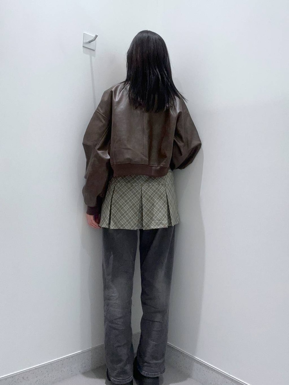 ブラック系のデニムパンツ、ブラック系のブーツ、ブラウン系のMA-1を着用したレディースの冬コーディネートの3枚目の写真