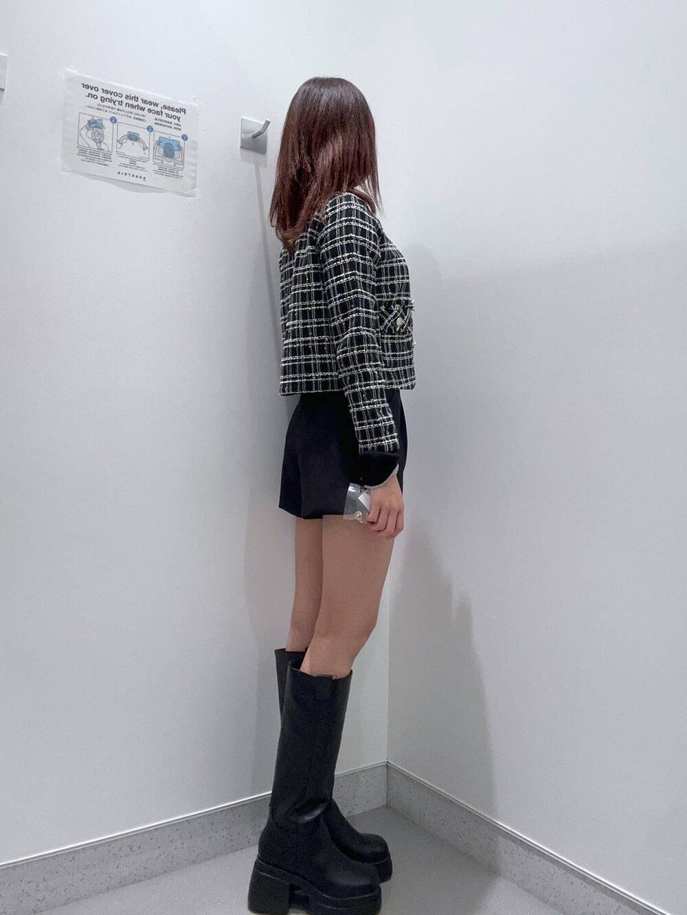 ブラック系のノーカラージャケット、ブラック系のニット/セーター、ブラック系のブーツを着用したレディースの冬コーディネートの2枚目の写真