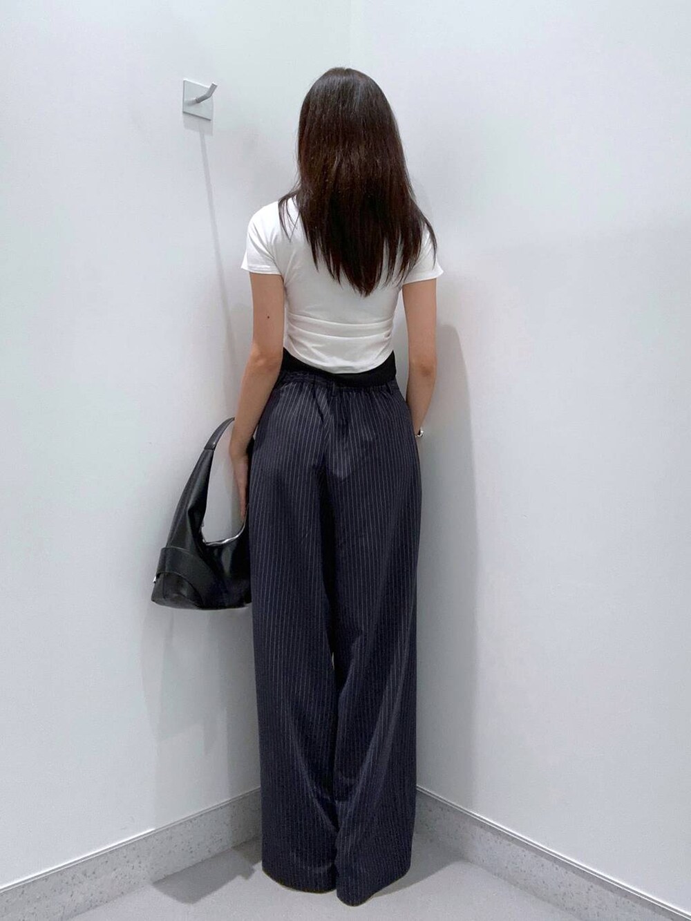 ブラック系のパンプス、ブラック系のショルダーバッグ、ブラック系のTシャツ/カットソーを着用したレディースの夏コーディネートの3枚目の写真