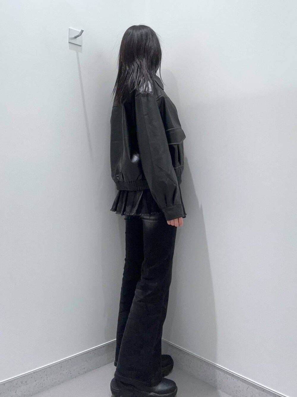 ブラック系のブーツ、ブラック系のデニムパンツ、ブラック系のデニムスカートを着用したレディースの冬コーディネートの2枚目の写真