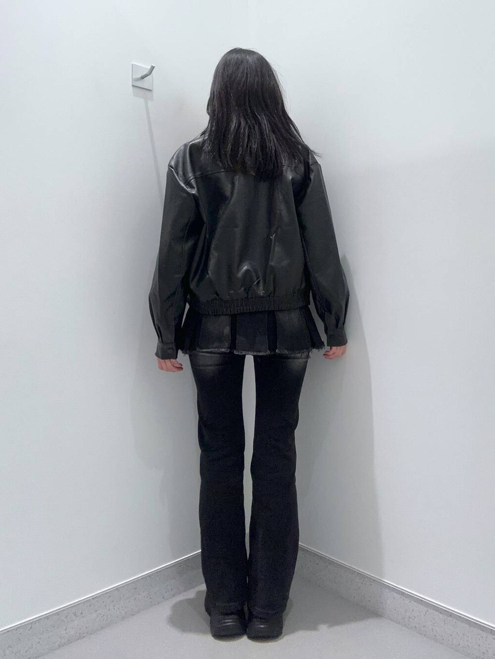 ブラック系のブーツ、ブラック系のデニムパンツ、ブラック系のデニムスカートを着用したレディースの冬コーディネートの3枚目の写真