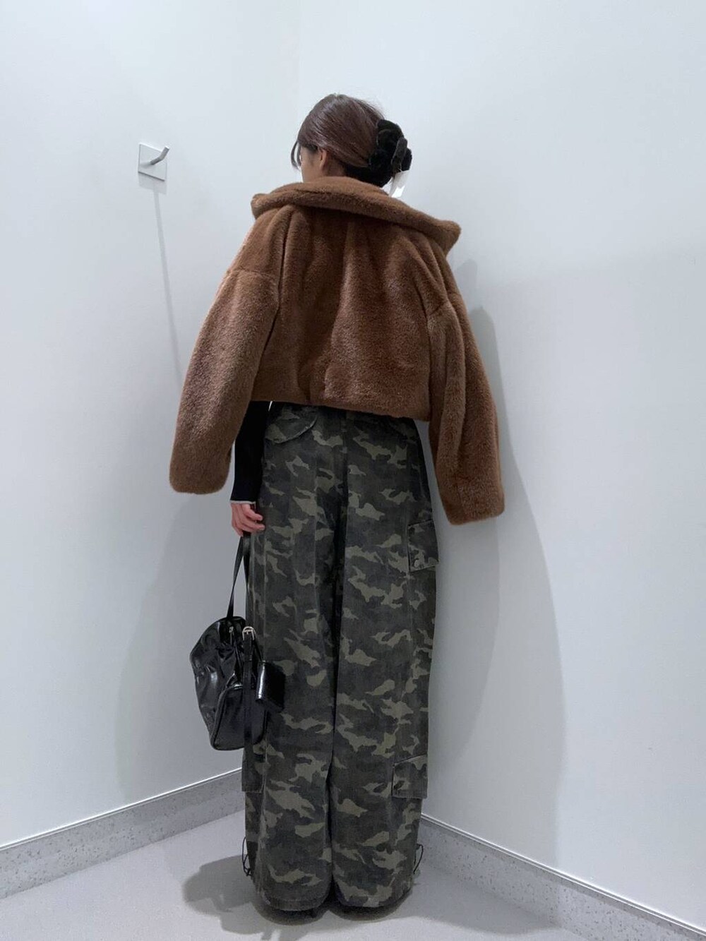 ブラウン系のブルゾン、ブラック系のニット/セーター、ブラック系のショルダーバッグを着用したレディースの秋コーディネートの3枚目の写真