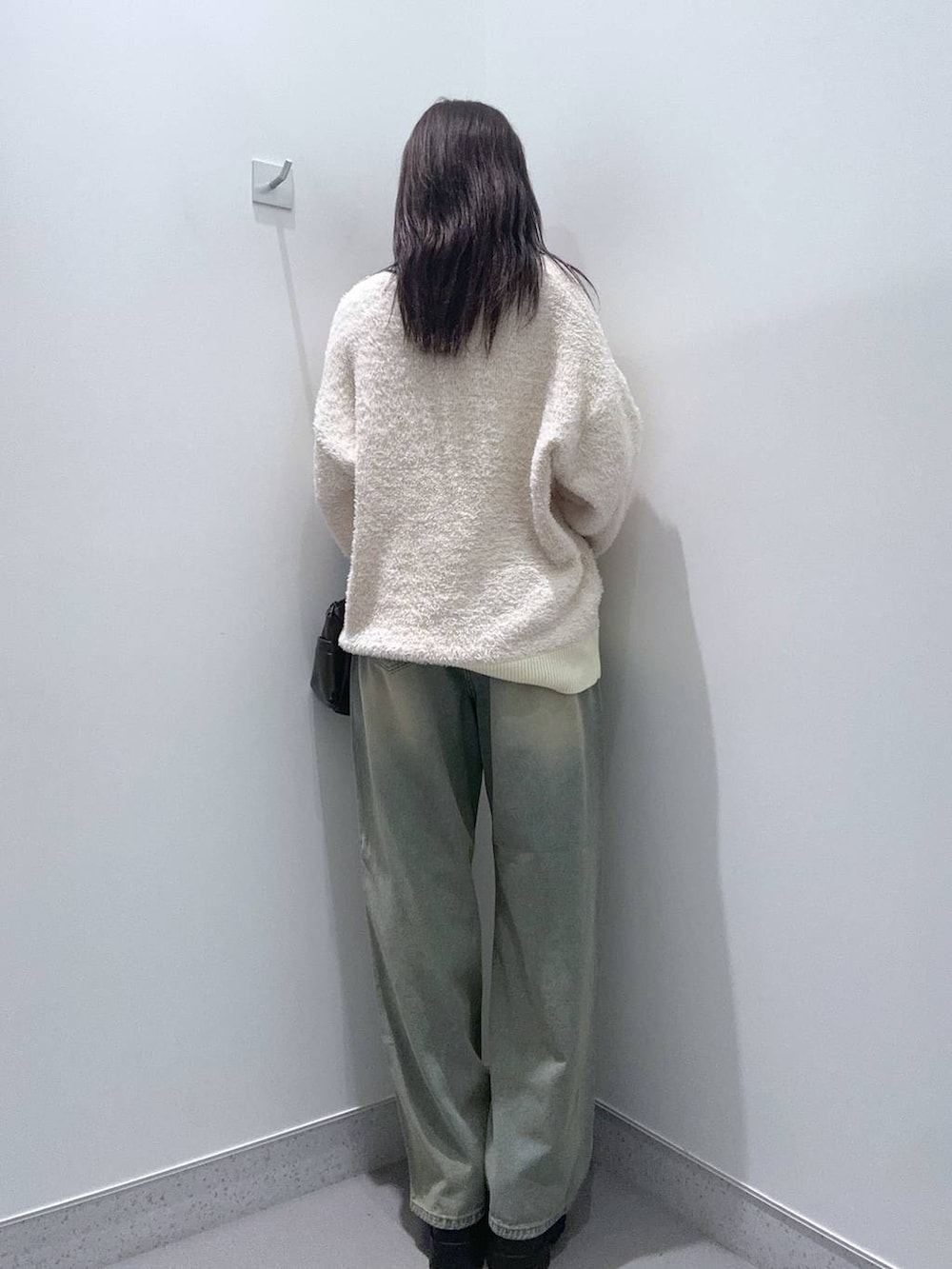 ブラウン系のショルダーバッグ、ブラウン系のローファー、ブルー系のデニムパンツを着用したレディースの秋コーディネートの3枚目の写真