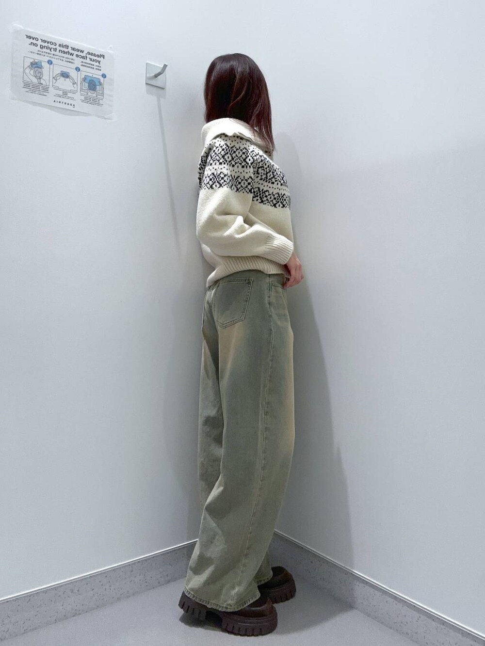 ブルー系のデニムパンツ、ブラウン系のブーツ、ベージュ系のニット/セーターを着用したレディースの冬コーディネートの2枚目の写真