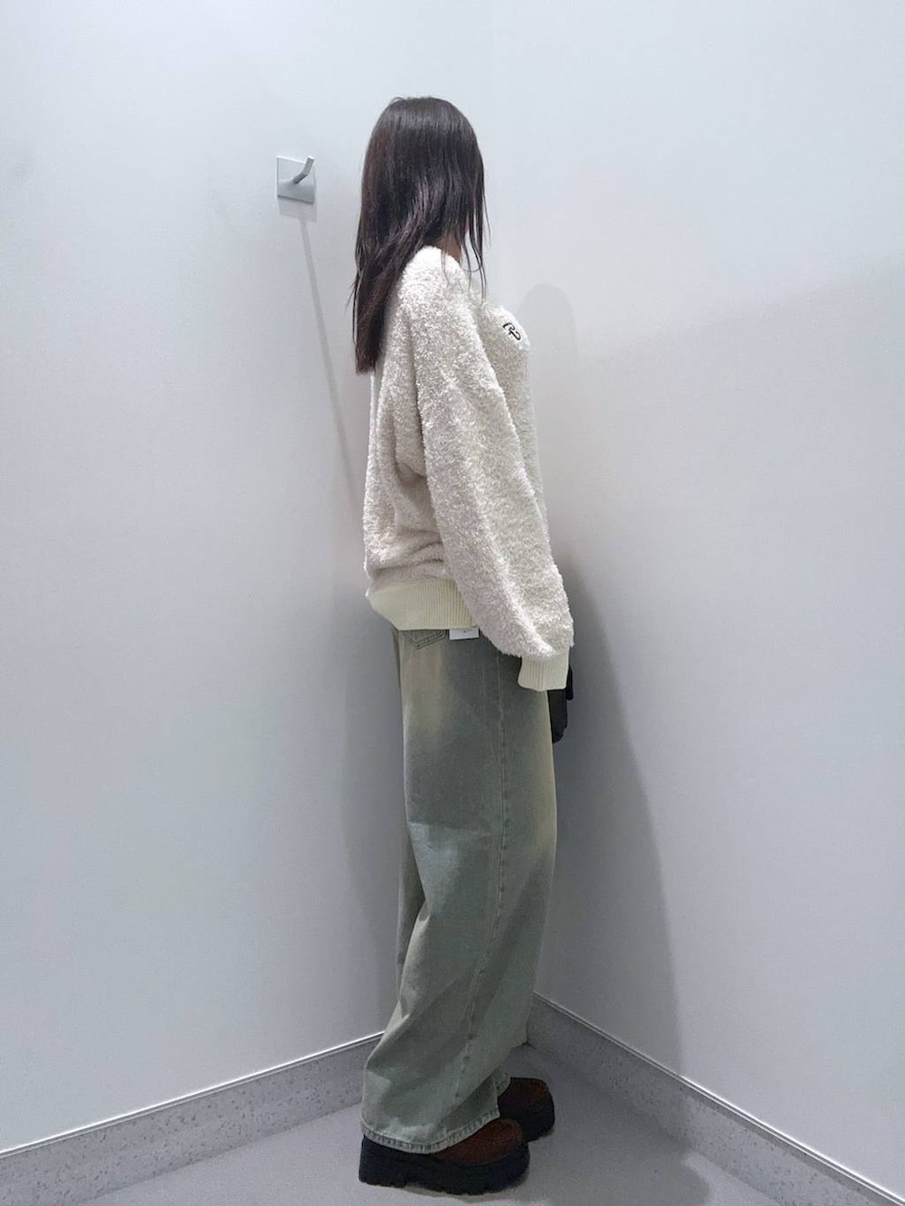 ブラウン系のショルダーバッグ、ブラウン系のローファー、ブルー系のデニムパンツを着用したレディースの秋コーディネートの2枚目の写真