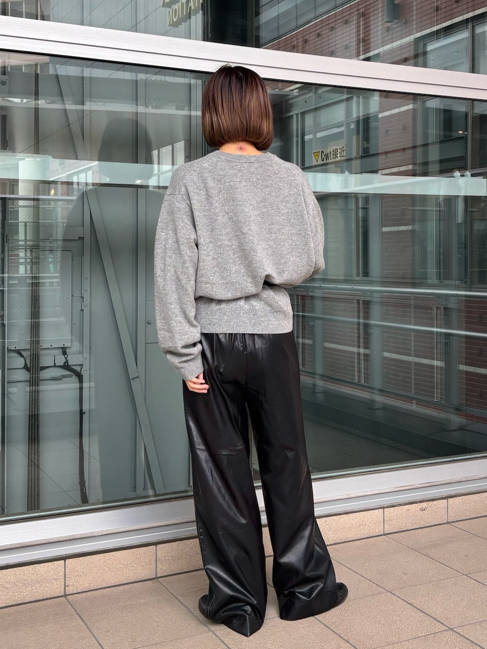 ブラック系のその他パンツ、ブラック系のボディバッグ/ウエストポーチ、グレー系のニット/セーターを着用したレディースの秋コーディネートの2枚目の写真