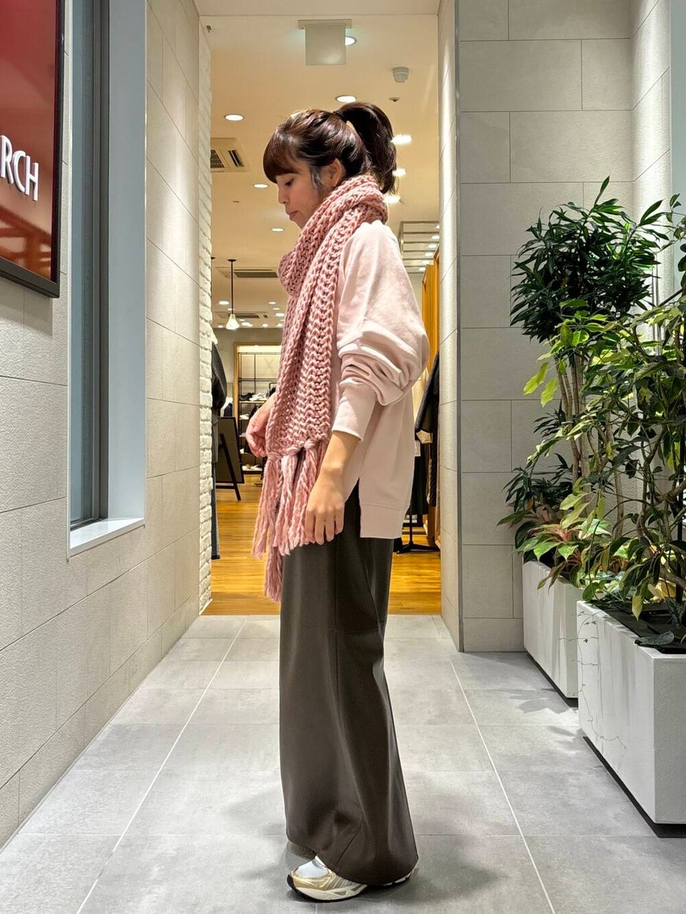 ホワイト系のスニーカー、ピンク系のTシャツ/カットソー、ブラウン系のスカートを着用したレディースの秋コーディネートの2枚目の写真