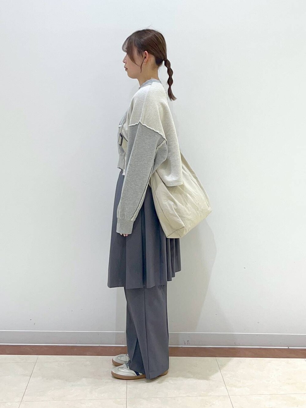 グレー系のスウェット、ベージュ系のショルダーバッグ、グレー系のその他パンツを着用したレディースの春コーディネートの2枚目の写真