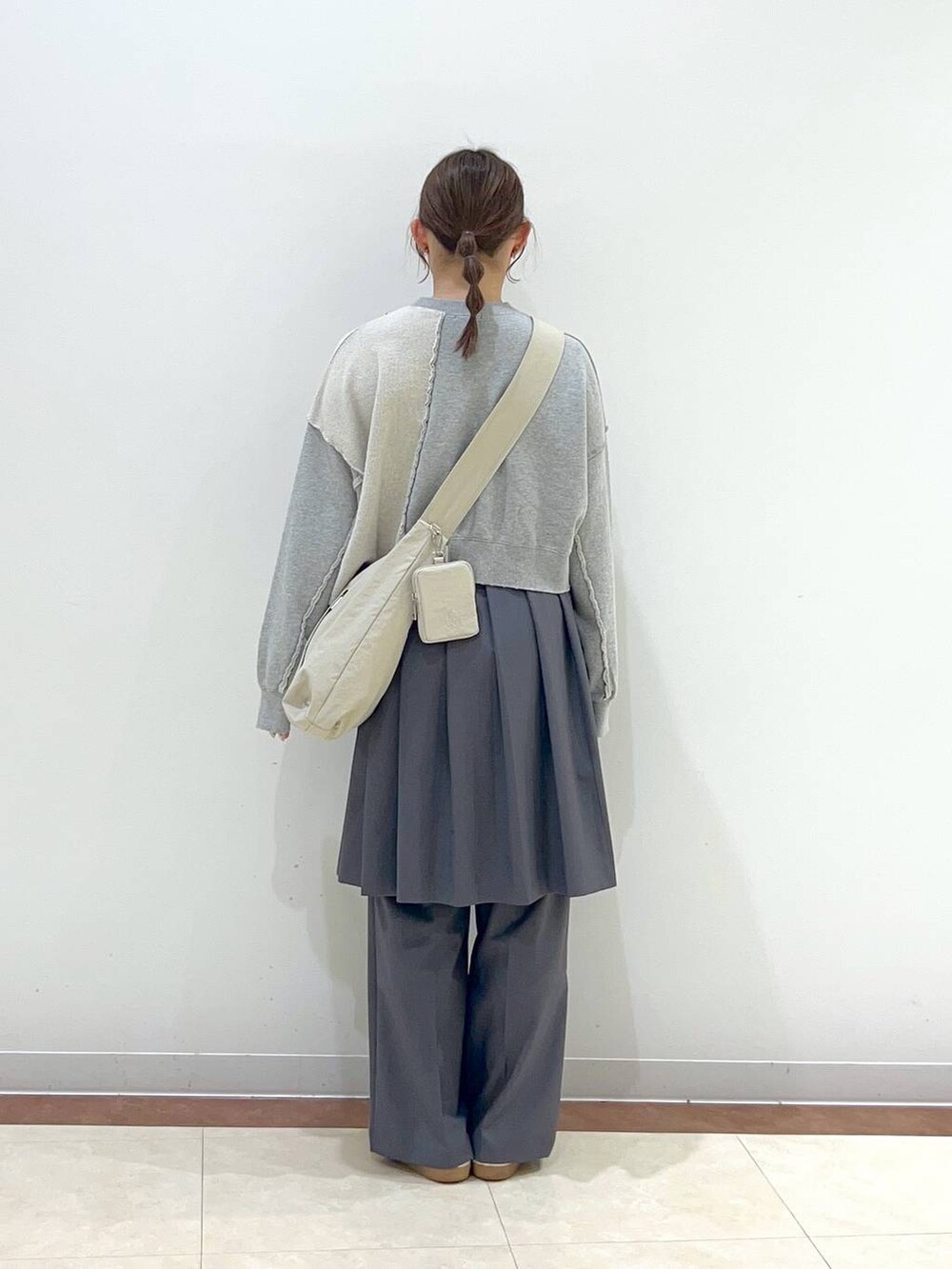 グレー系のスウェット、ベージュ系のショルダーバッグ、グレー系のその他パンツを着用したレディースの春コーディネートの3枚目の写真