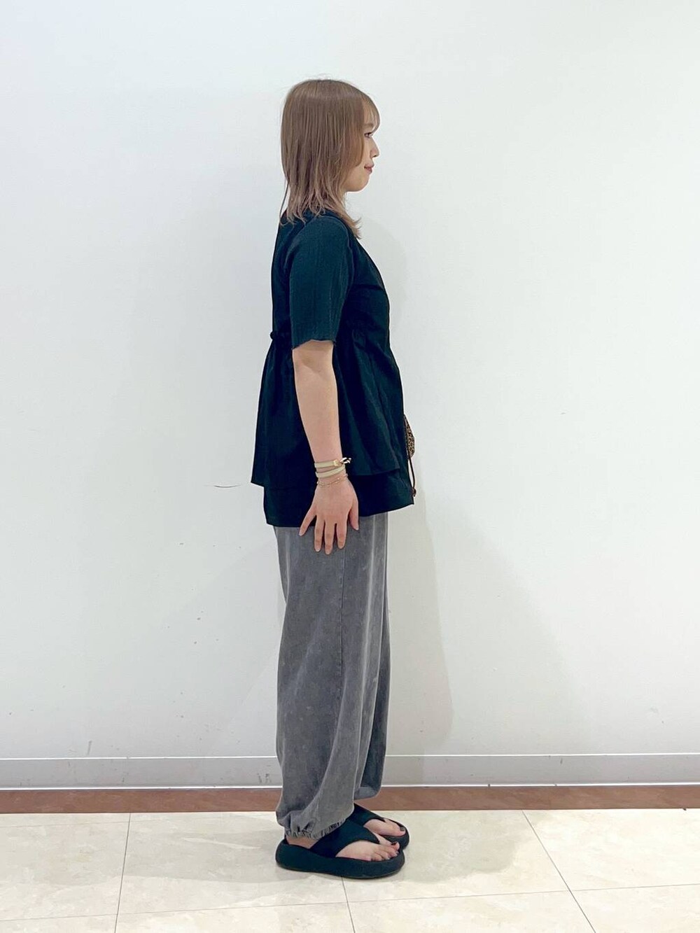 ブラック系のサンダル、グレー系のTシャツ/カットソー、ブラック系のベストを着用したレディースの夏コーディネートの2枚目の写真