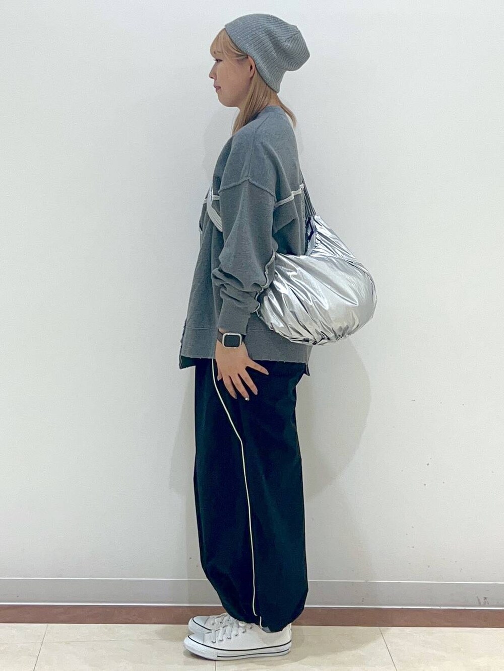 ブラック系のカーゴパンツ、グレー系のスウェット、シルバー系のショルダーバッグを着用したレディースの秋コーディネートの2枚目の写真