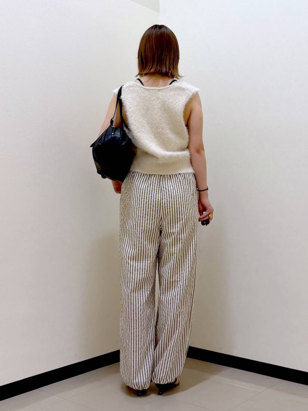 ブラック系のTシャツ/カットソー、ブラック系のボストンバッグ、ブラック系のサンダルを着用したレディースの夏コーディネートの3枚目の写真