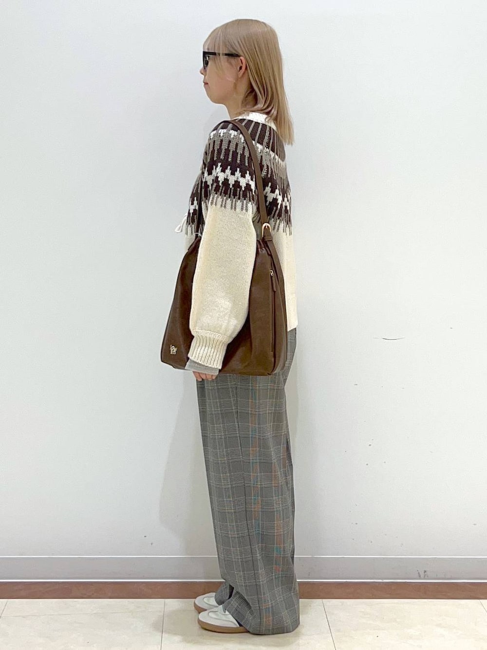 ブラウン系のショルダーバッグ、グレー系のスラックス、ホワイト系のTシャツ/カットソーを着用したレディースの秋コーディネートの2枚目の写真