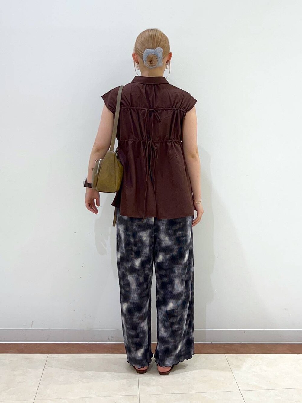 ブラック系のその他パンツ、ブラウン系のサンダル、ブラウン系のショルダーバッグを着用したレディースの夏コーディネートの3枚目の写真