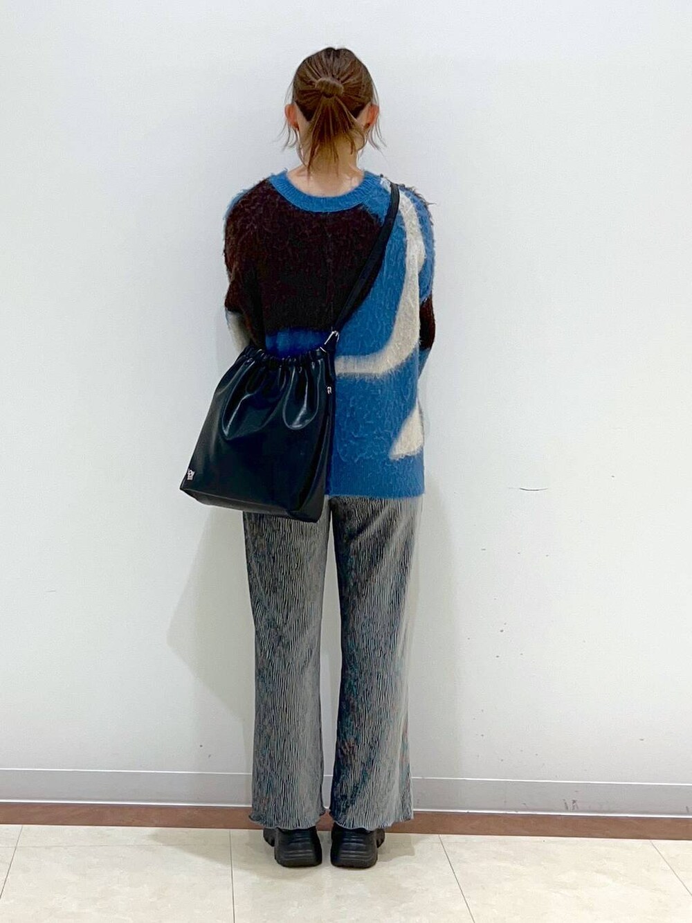 ブラック系のブーツ、グレー系のその他パンツ、ブルー系のニット/セーターを着用したレディースの冬コーディネートの3枚目の写真