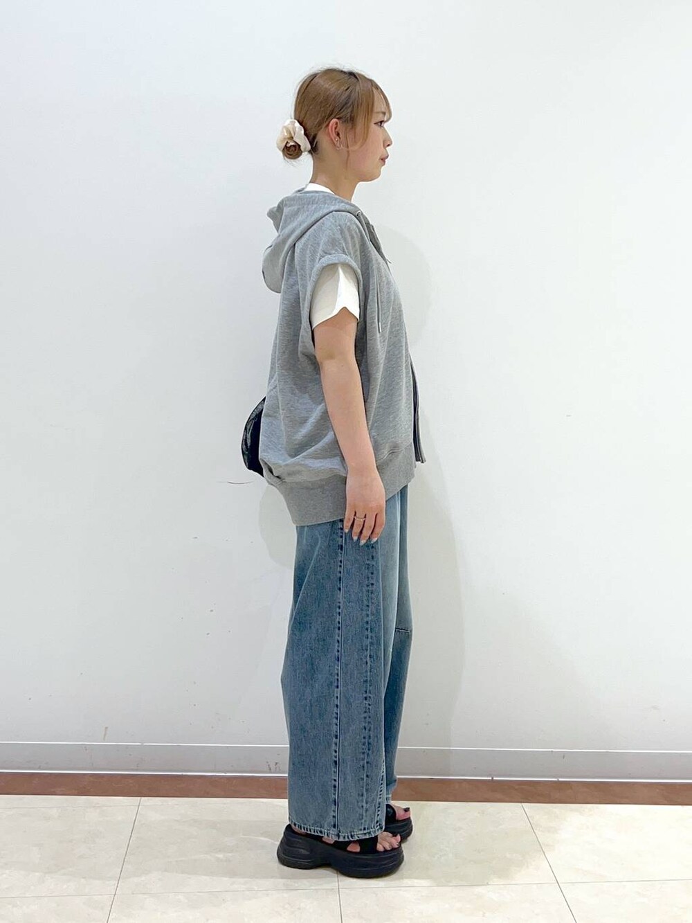 ブラック系のサンダル、ホワイト系のTシャツ/カットソー、ブルー系のデニムパンツを着用したレディースの夏コーディネートの2枚目の写真