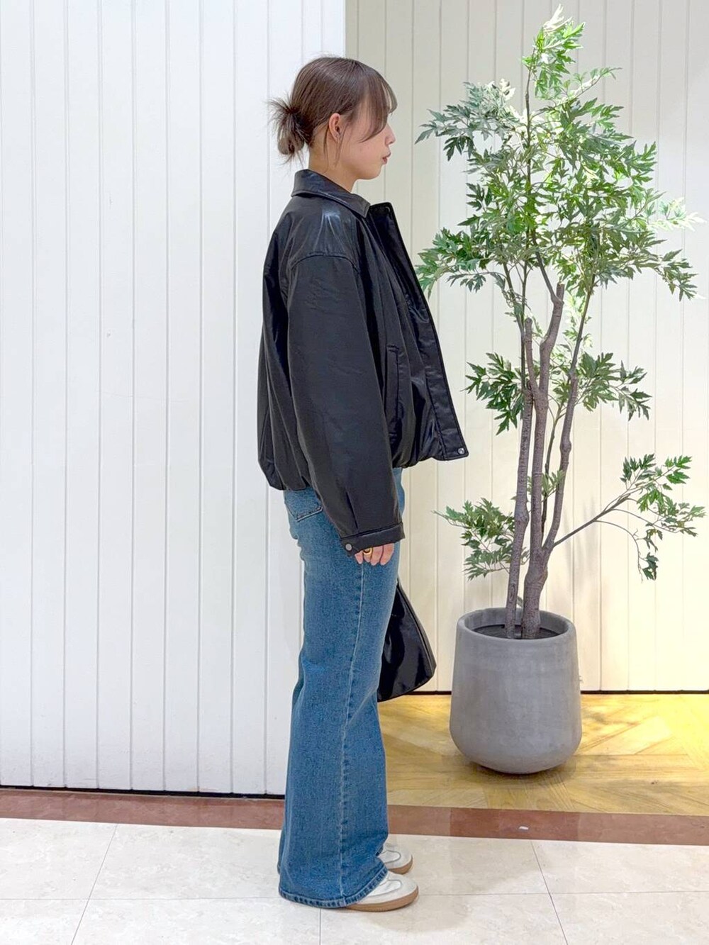 グレー系のスウェット、ブラック系のブルゾン、ブルー系のデニムパンツを着用したレディースの冬コーディネートの2枚目の写真