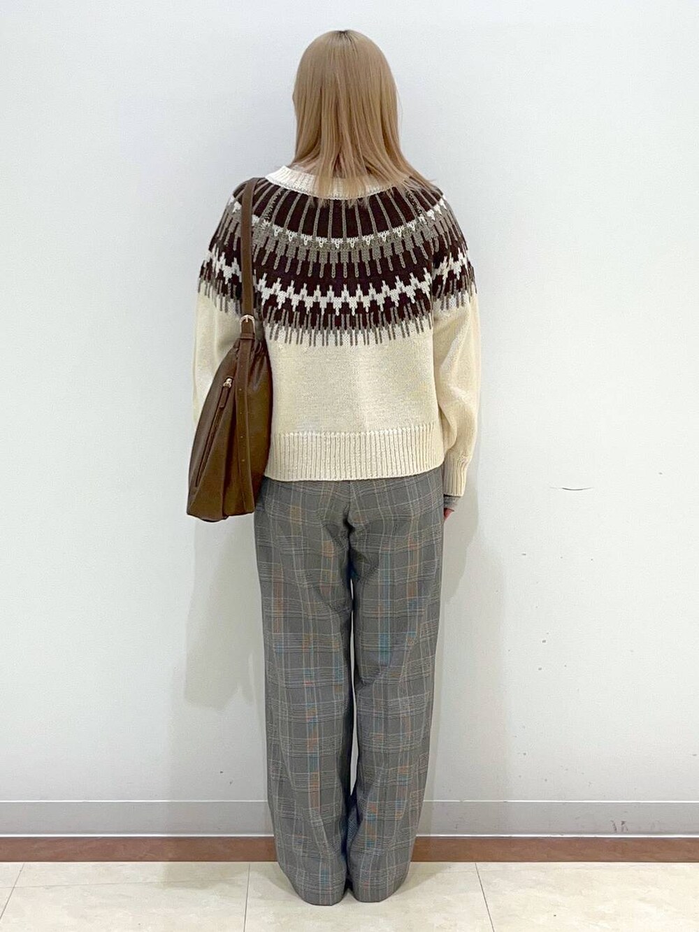 ブラウン系のショルダーバッグ、グレー系のスラックス、ホワイト系のTシャツ/カットソーを着用したレディースの秋コーディネートの3枚目の写真