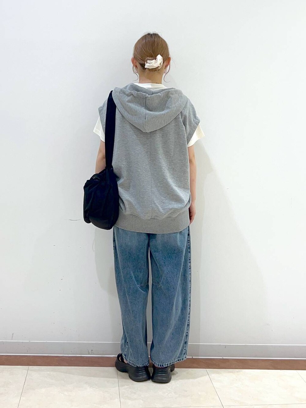 ブラック系のサンダル、ホワイト系のTシャツ/カットソー、ブルー系のデニムパンツを着用したレディースの夏コーディネートの3枚目の写真