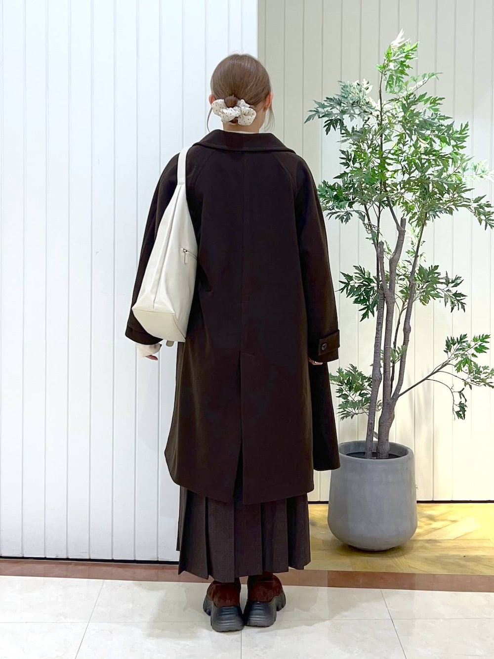 ブラウン系のショルダーバッグ、ブラウン系のブーツ、ブラウン系のスカートを着用したレディースの秋コーディネートの3枚目の写真