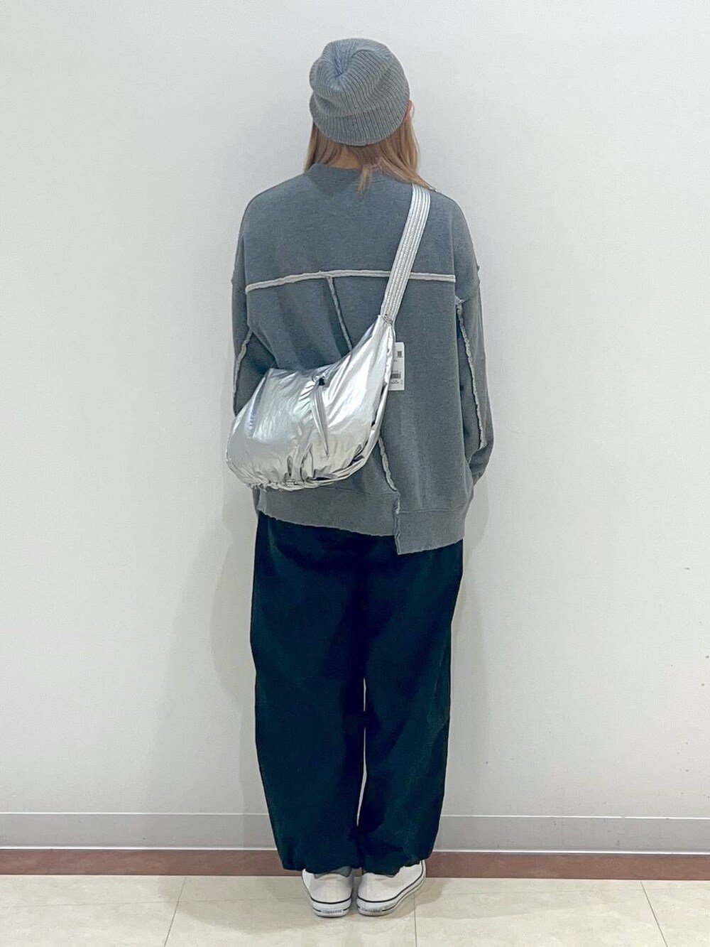 ブラック系のカーゴパンツ、グレー系のスウェット、シルバー系のショルダーバッグを着用したレディースの秋コーディネートの3枚目の写真