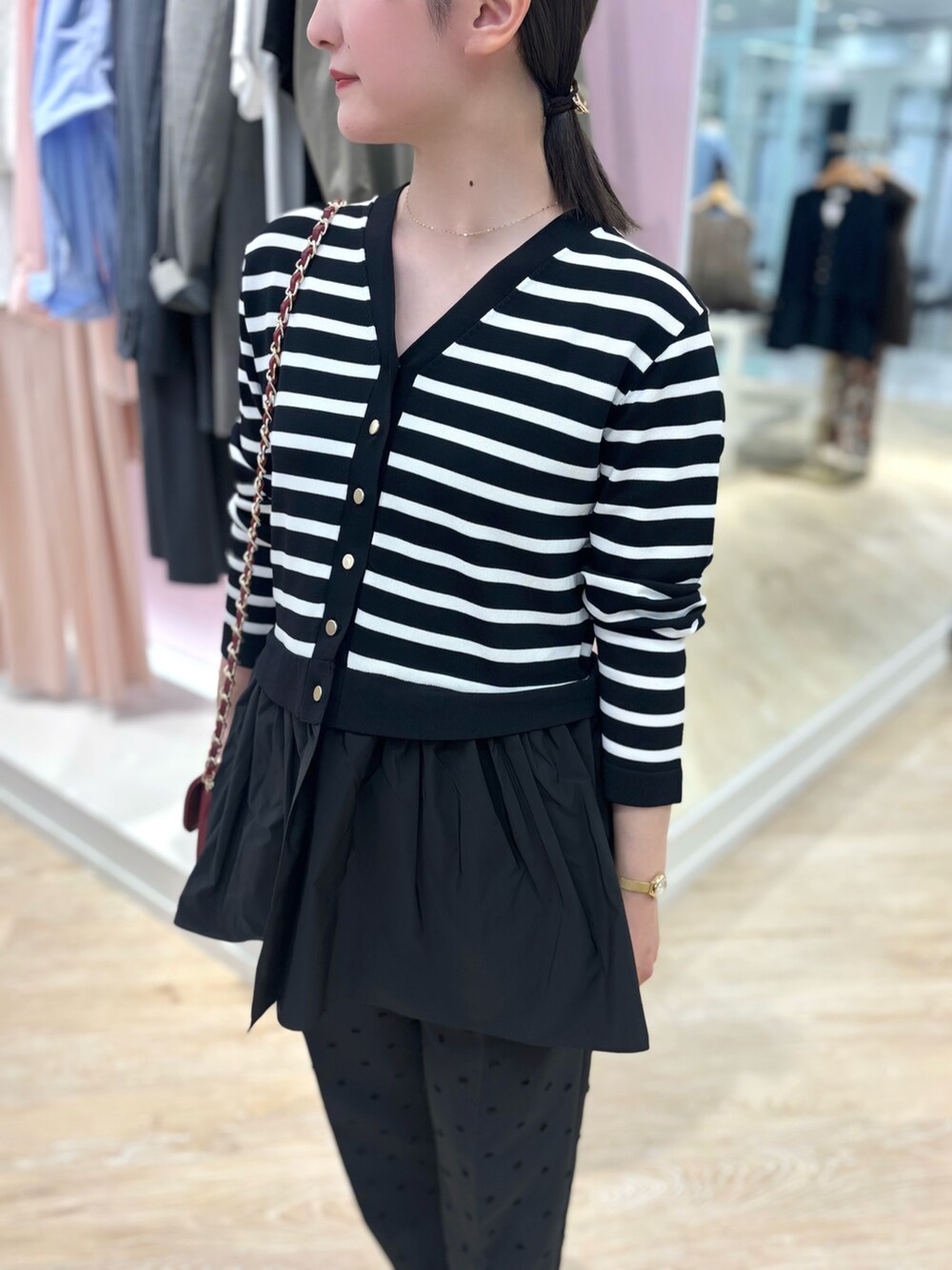 ブラック系のカーディガン/ボレロ、ブラック系のその他パンツ、レッド系のショルダーバッグを着用したレディースの秋コーディネートの7枚目の写真