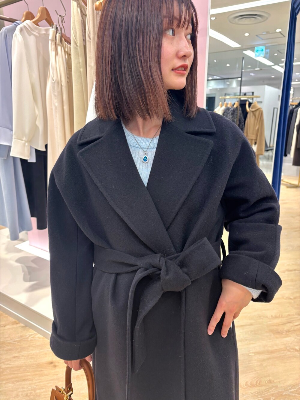 ベージュ系のスカート、ブルー系のニット/セーター、ブルー系のその他アウターを着用したレディースの冬コーディネートの5枚目の写真