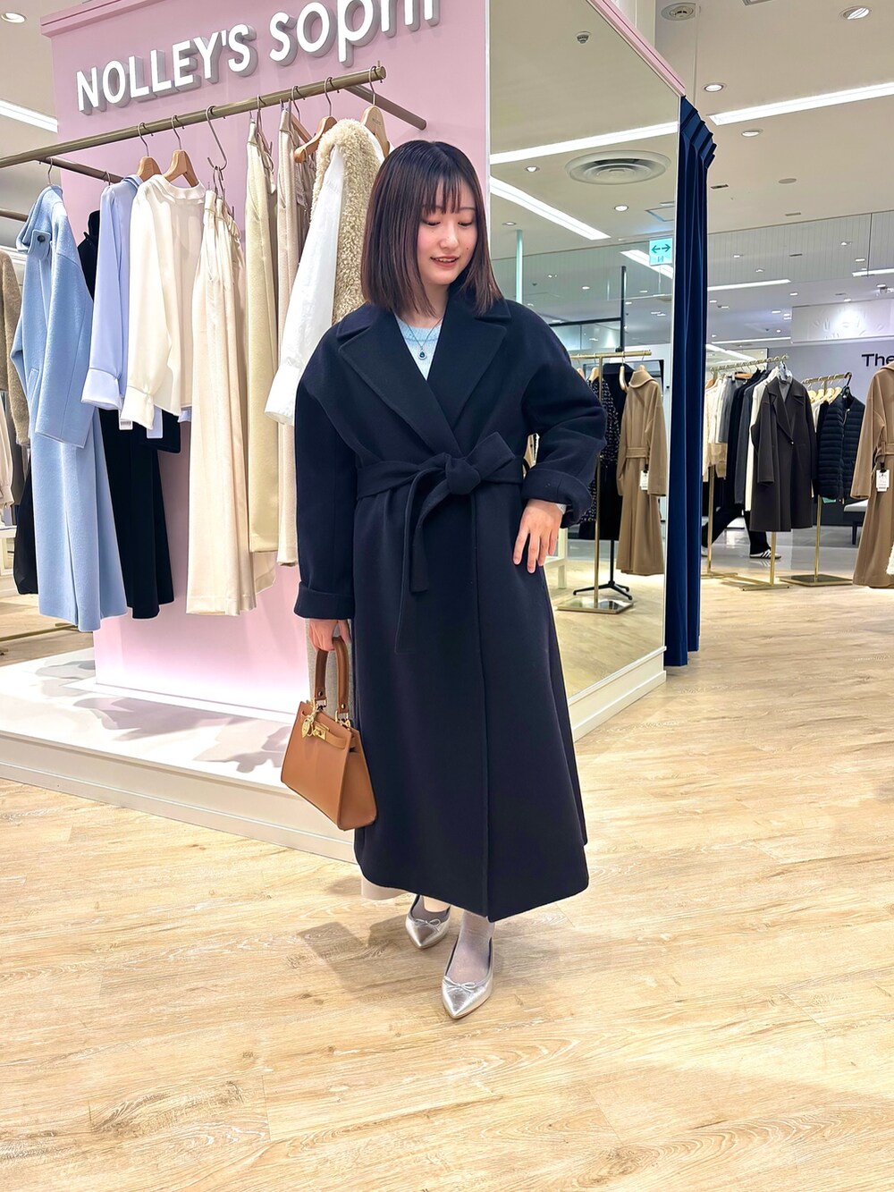 ベージュ系のスカート、ブルー系のニット/セーター、ブルー系のその他アウターを着用したレディースの冬コーディネートの3枚目の写真