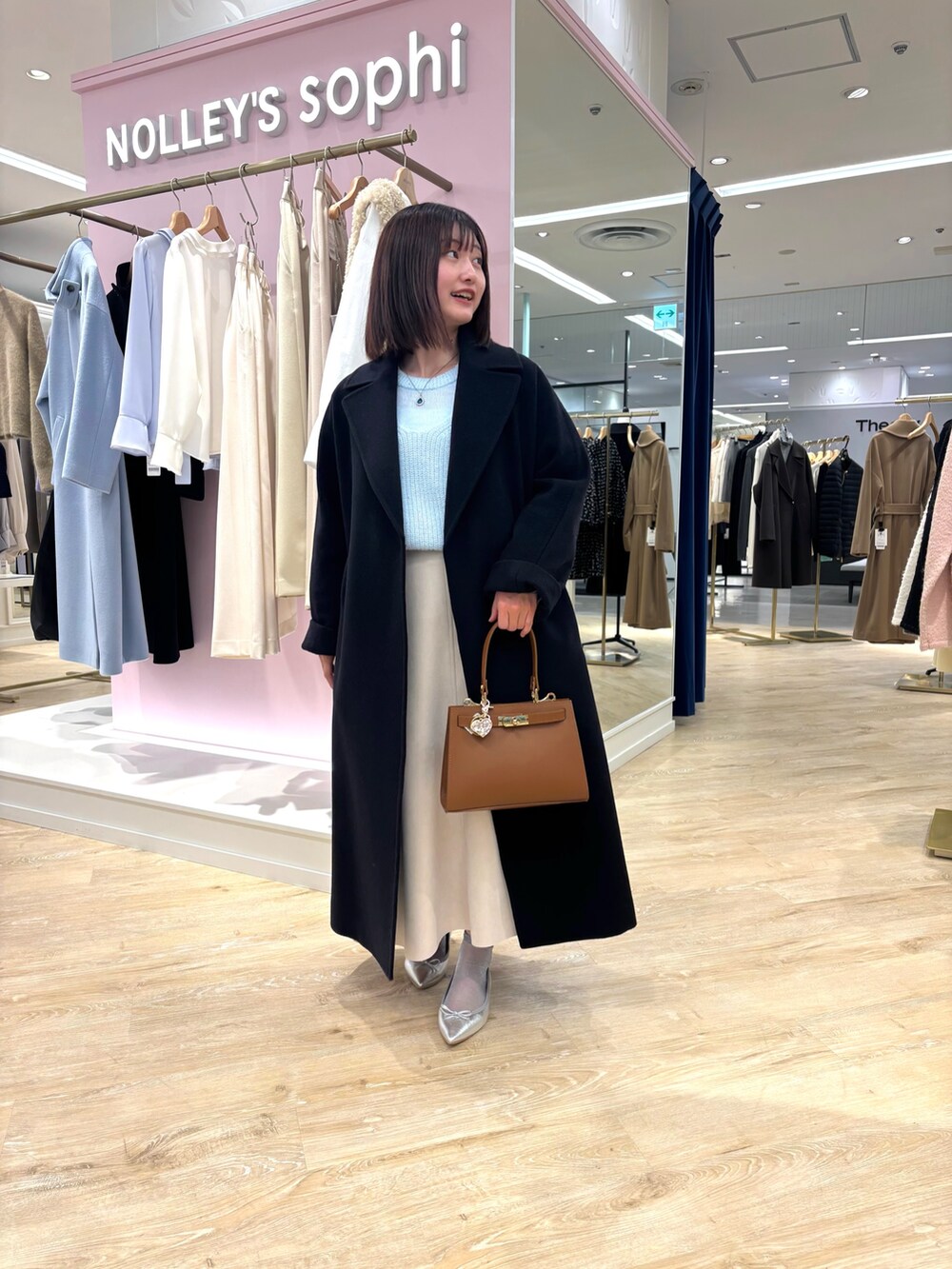 ベージュ系のスカート、ブルー系のニット/セーター、ブルー系のその他アウターを着用したレディースの冬コーディネートの7枚目の写真