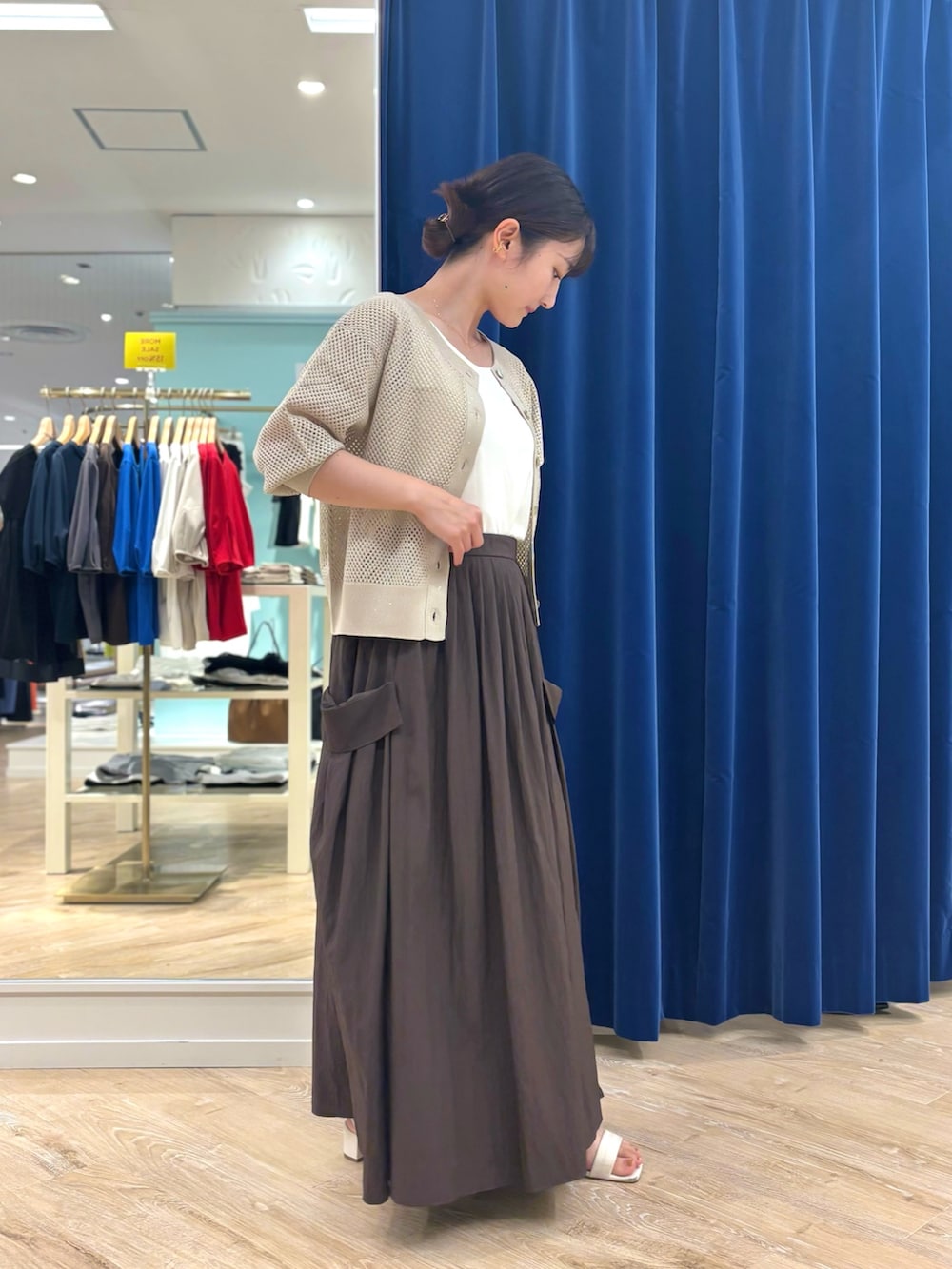 ブラウン系のスカート、レッド系のボストンバッグ、ベージュ系のカーディガン/ボレロを着用したレディースの夏コーディネートの5枚目の写真