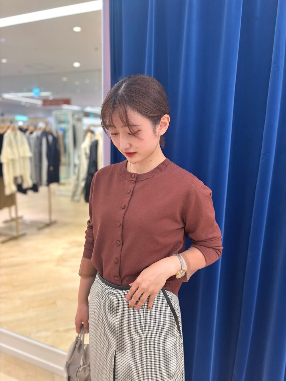 ブラック系のスカート、ベージュ系のショルダーバッグ、ブラウン系のカーディガン/ボレロを着用したレディースの秋コーディネートの8枚目の写真