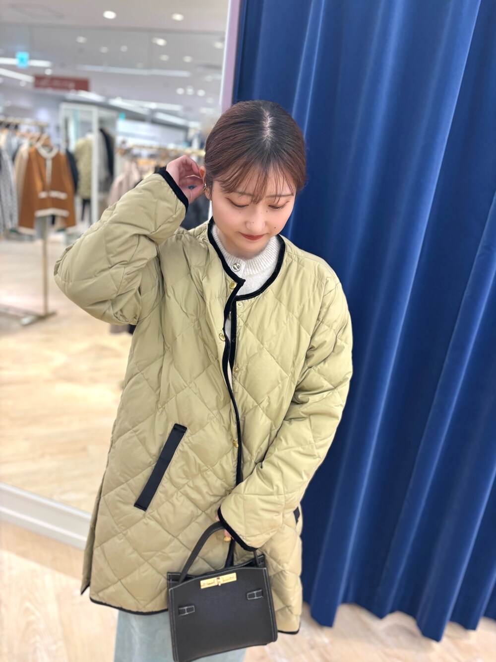 ベージュ系のダウンジャケット/コート、ブラック系のショルダーバッグ、グリーン系のスカートを着用したレディースの秋コーディネートの9枚目の写真