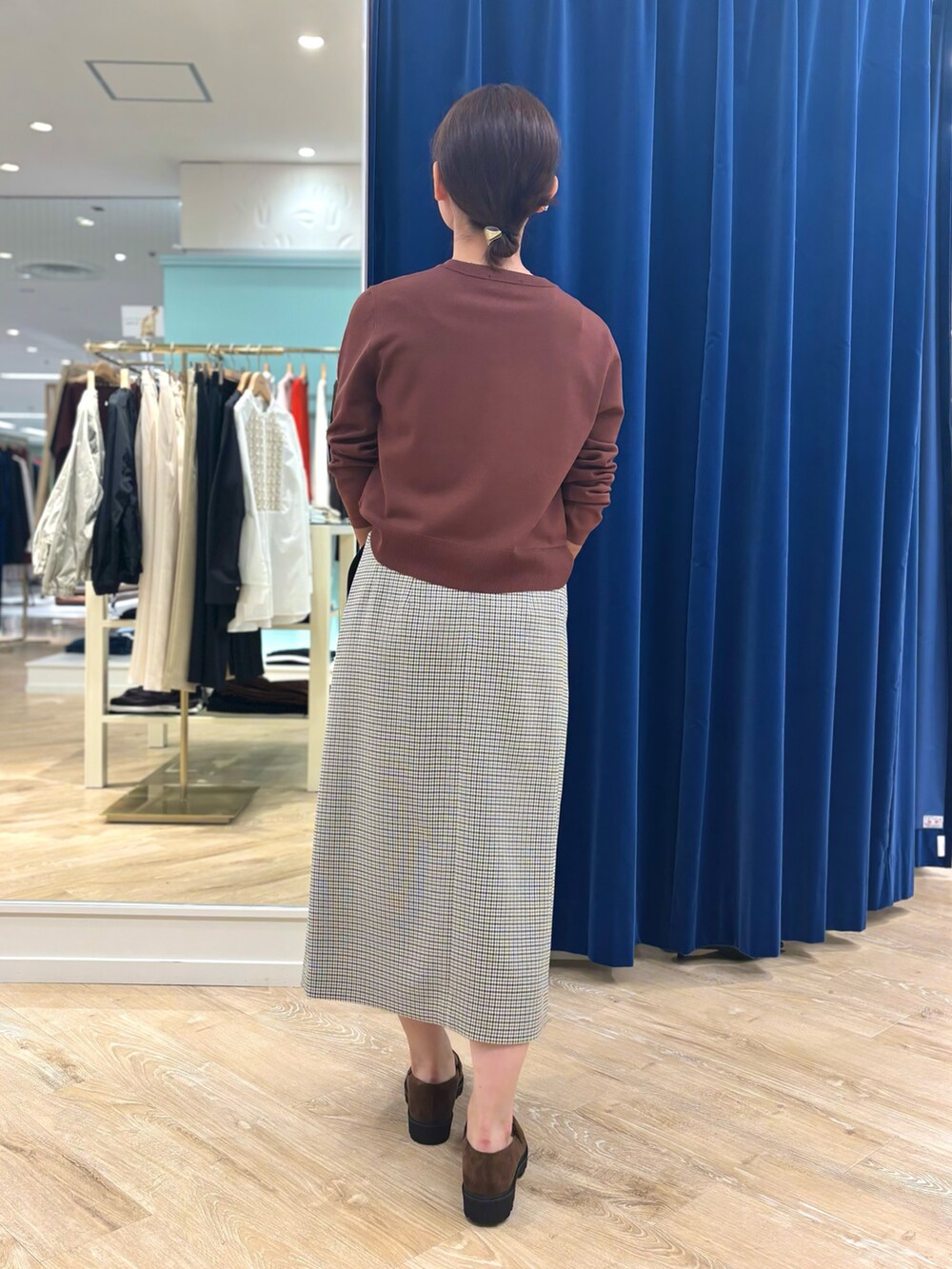 ブラック系のスカート、ベージュ系のショルダーバッグ、ブラウン系のカーディガン/ボレロを着用したレディースの秋コーディネートの4枚目の写真